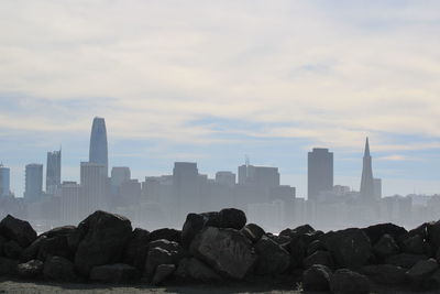 View of buildings in city against cloudy sky
