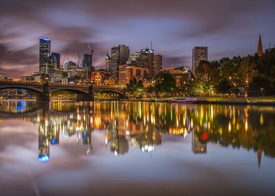 Reflection of illuminated buildings in river at night