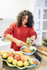 Brunette woman making a healthy green salad.