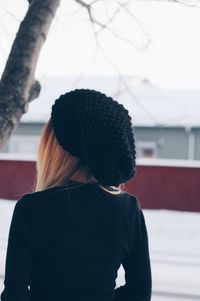 Rear view of woman standing against wall