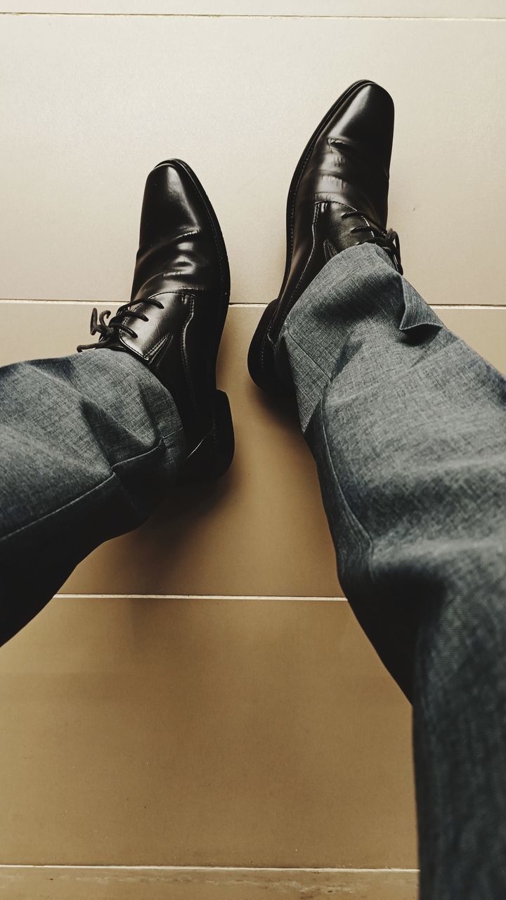 black, shoe, human leg, low section, footwear, indoors, limb, human limb, adult, men, one person, lifestyles, clothing, human foot, casual clothing, jeans, personal perspective, flooring, leather, arm, relaxation, high angle view, leisure activity, fashion, business