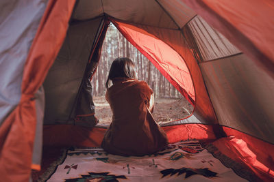 Rear view of women sitting at tent