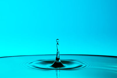 Close-up of water drop on blue surface