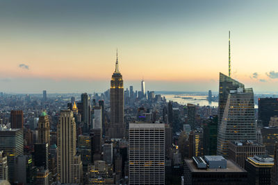 Modern buildings in city against sky during sunset