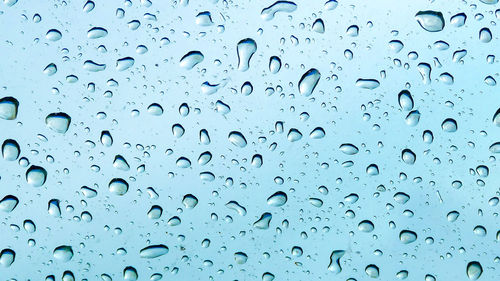 Close-up of wet glass window during rainy season