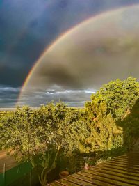 Scenic view of rainbow over landscape against sky