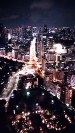 Illuminated cityscape against sky at night
