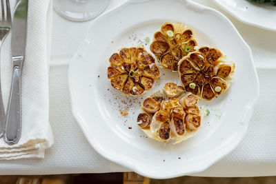 Roasted garlic dish in olive oil in luxury restaurant. white beautiful restaurant europe style.