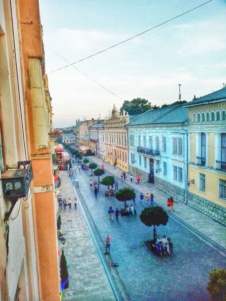 architecture, building exterior, built structure, large group of people, street, city, sky, city life, person, town square, travel, transportation, road, travel destinations, incidental people, mixed age range, walking, tourism, famous place