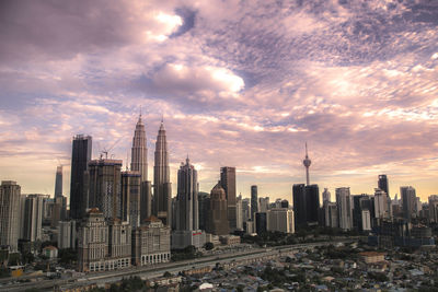 Modern buildings in city against cloudy sky