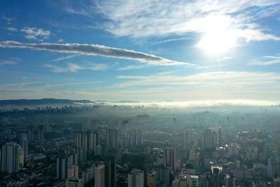 Aerial view of buildings in city against sky