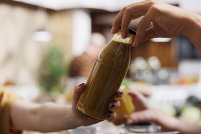 Cropped hand of woman holding drink