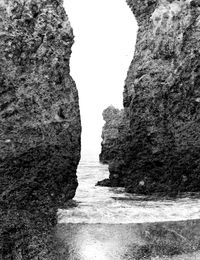 Rock formation amidst sea against clear sky