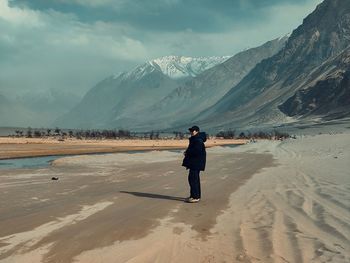 Full length rear view of woman walking at beach