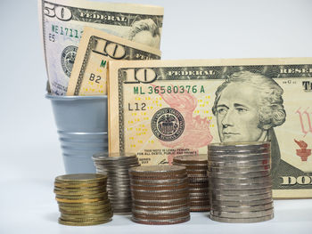 Close-up of coins on shelf against white background