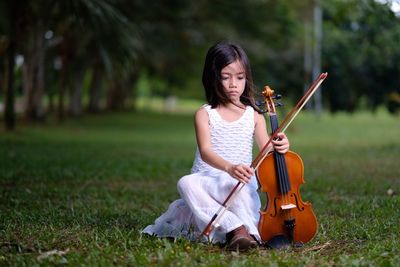 Girl playing violin on field
