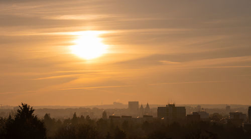 Silhouette buildings against sky during sunset