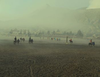 Group of people on landscape against sky