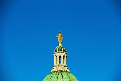 Low angle view of statue against blue sky