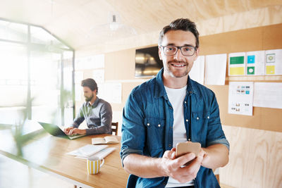 Portrait of a smiling young man using smart phone