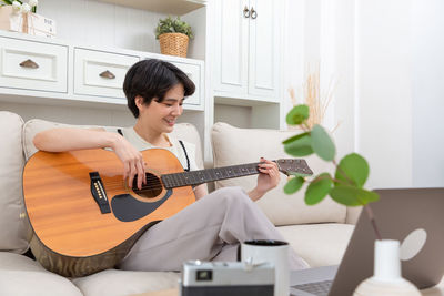 Man playing guitar at home