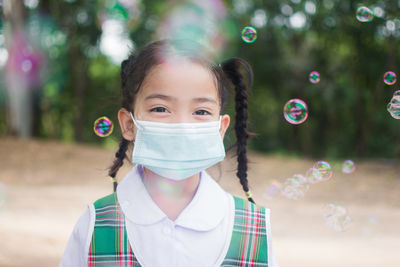 Portrait of girl wearing mask with bubbles