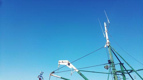 Low angle view of boat mast against clear blue sky