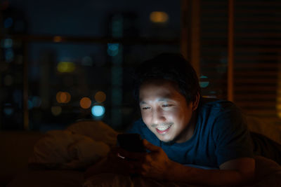 Portrait of young man using mobile phone at home