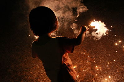 Rear view of girl burning sparkler