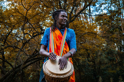 Mid adult man standing against trees