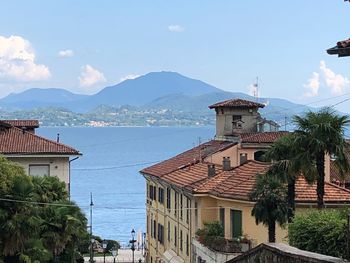 View of buildings by sea against sky