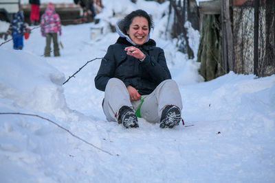 Woman sitting on snow covered field