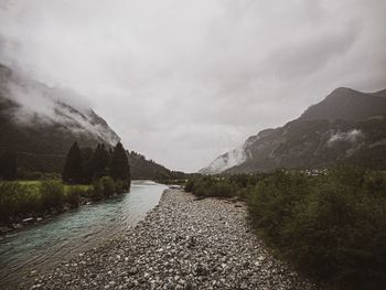 Scenic view of river against sky during rainy season