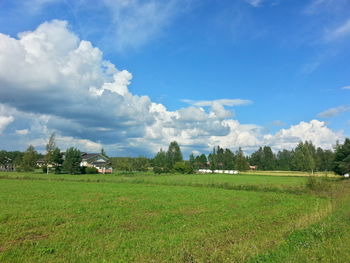 Scenic view of grassy field against cloudy sky