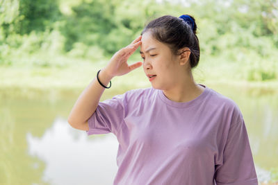 Side view of young woman looking away while standing outdoors