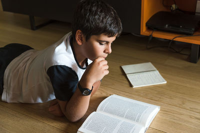 Boy reading book at home