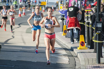 Group of people running on footpath