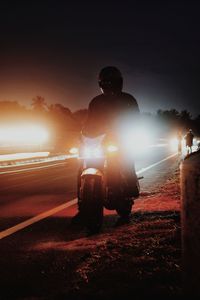 Silhouette man standing on road against sky at night