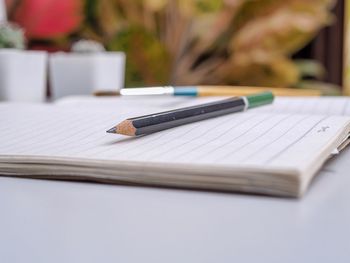 Close-up of book and pencil on table