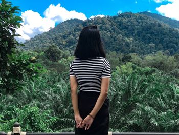 Rear view of woman looking at green mountain