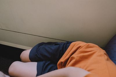 Low section of man relaxing on bed