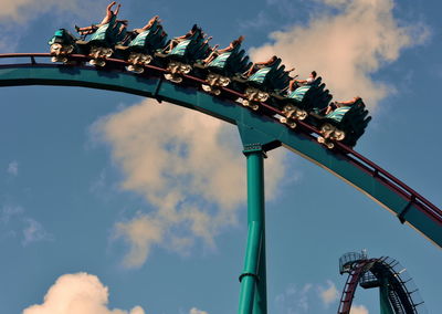 Low angle view of chain swing ride against sky