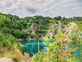 Scenic view of river against cloudy sky