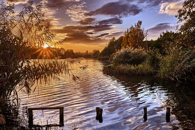 Scenic view of lake against sky at sunset
