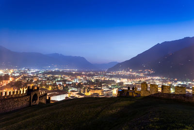 View of illuminated town against blue sky