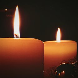 Close-up of lit candle in dark room