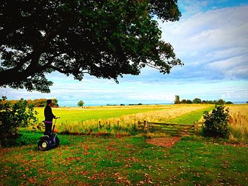 Scenic view of grassy field against cloudy sky