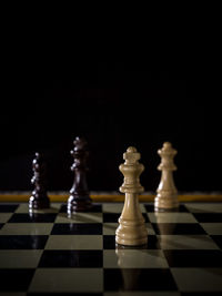 Close-up of chess pieces on table against black background