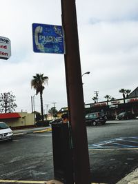 Road sign against cloudy sky