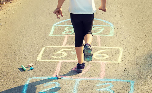 Rear view of woman walking on road